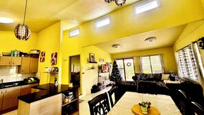 Un intérieur lumineux aux couleurs jaune vif, comprenant une cuisine, un coin repas et un espace de vie.