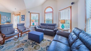 A living room with a blue sofa, two armchairs, a coffee table, and a patterned rug. - Knot A Care - Corolla, Ocean Sands, 400 Yds to Beach, Pool, Hot Tub, Pool Table, Pets OK (Corolla)