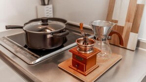A kitchen with a stove, a coffee maker, and a pot on the counter. - Chuan House Asahi (Osaka)