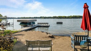 A lakeside dock with a covered boat, a bench, and a red umbrella. - Lakefront Getaway, Swim, Laugh, Family Fun for all! Close to Kettle Moraine (Palmyra)