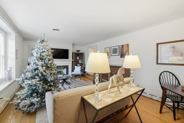 A living room with a Christmas tree, a fireplace, and a dining area with two lamps. - 4 Mins to U of R! Spacious, Central Guest Suite (Richmond)