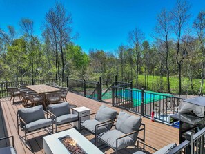 A deck with outdoor furniture, a fire pit, and a view of a swimming pool. - ELK COVE - Modern Pocono Cabin - Pool - Pickleball (Blakeslee)