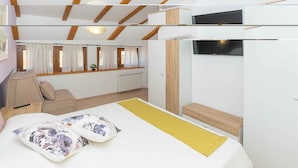 A bedroom with a bed, a bedside table, a TV, and a window with curtains. - Holiday home with air conditioning (Vodnjan)