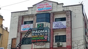 Ein mehrgeschossiges Gebäude mit Schildern für Hotel Best Inn und Padma Clinic.