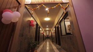 Ein Hotelgang mit einem Schild, auf dem 'HOTEL BEST INN' steht, und einem Warnschild für Videoüberwachung.
