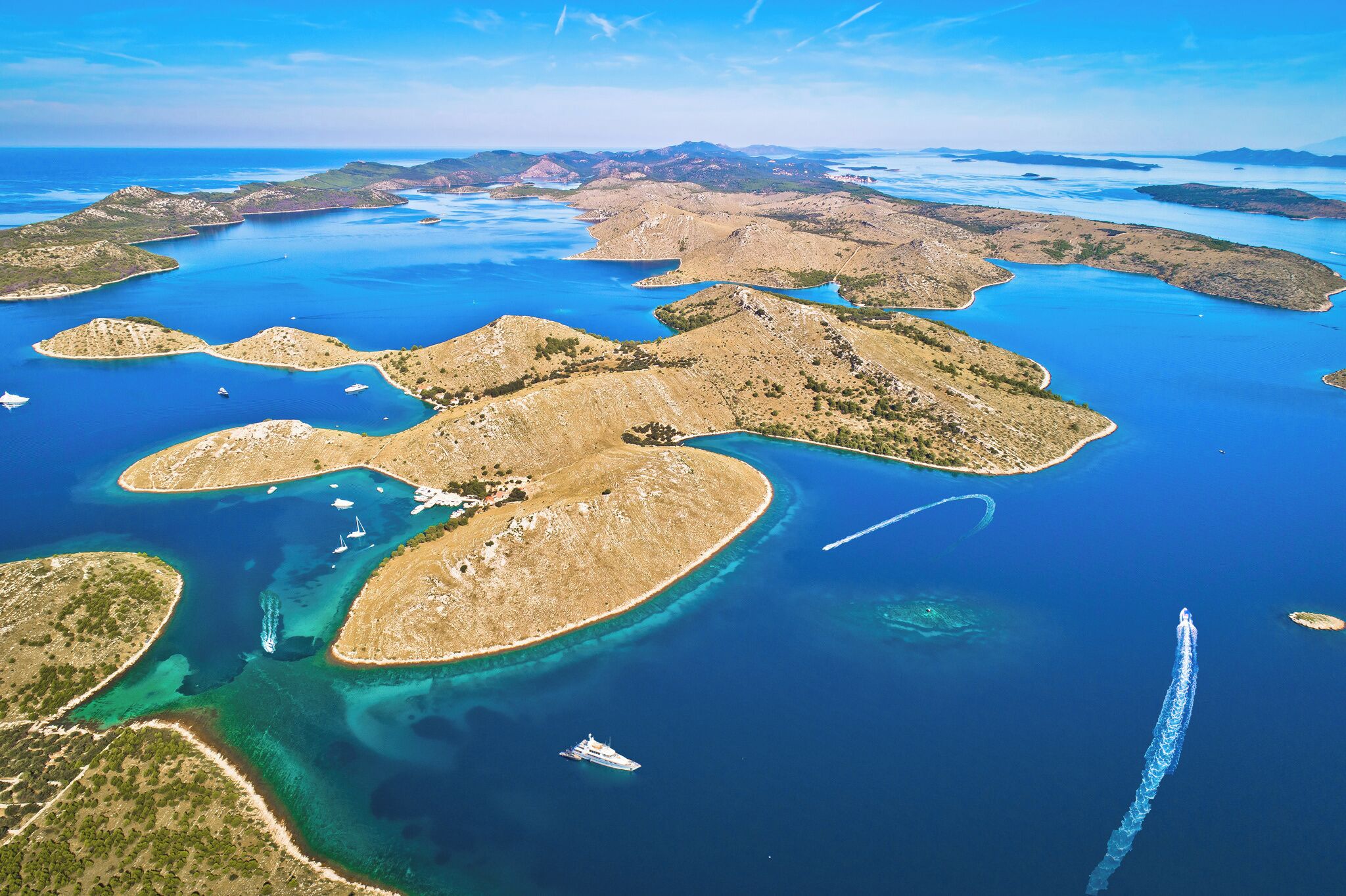 Vue aérienne d’une zone côtière avec de nombreuses îles et des eaux d’un bleu limpide.