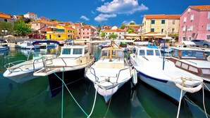 Un puerto deportivo con barcos amarrados, rodeado de edificios coloridos.