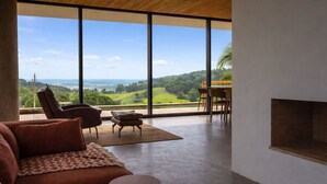 A spacious living area with a large window offering a view of a green landscape and distant hills. - Casa c Piscina e Vista Panor Mica Bueno Brand o (Pouso Alegre)
