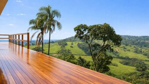 A wooden deck with a view of a lush green landscape and hills. - Casa c Piscina e Vista Panor Mica Bueno Brand o (Pouso Alegre)