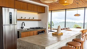 A modern kitchen with a stainless steel refrigerator, wooden cabinets, a gas stove, and a large island with bar stools. - Casa c Piscina e Vista Panor Mica Bueno Brand o (Pouso Alegre)