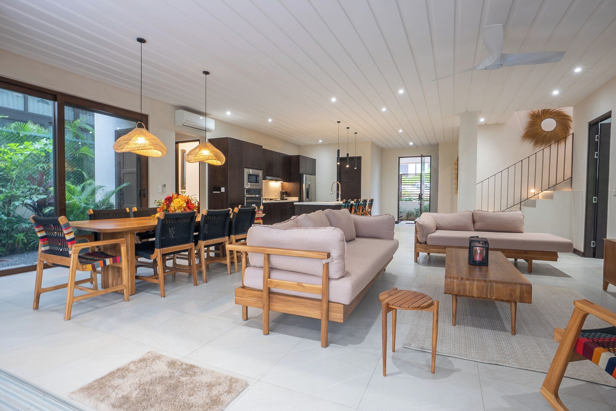 A modern living room with a sofa, coffee table, dining table, and chairs.
