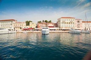 Un port de plaisance où sont amarrés plusieurs yachts, entouré de bâtiments à l’architecture classique.