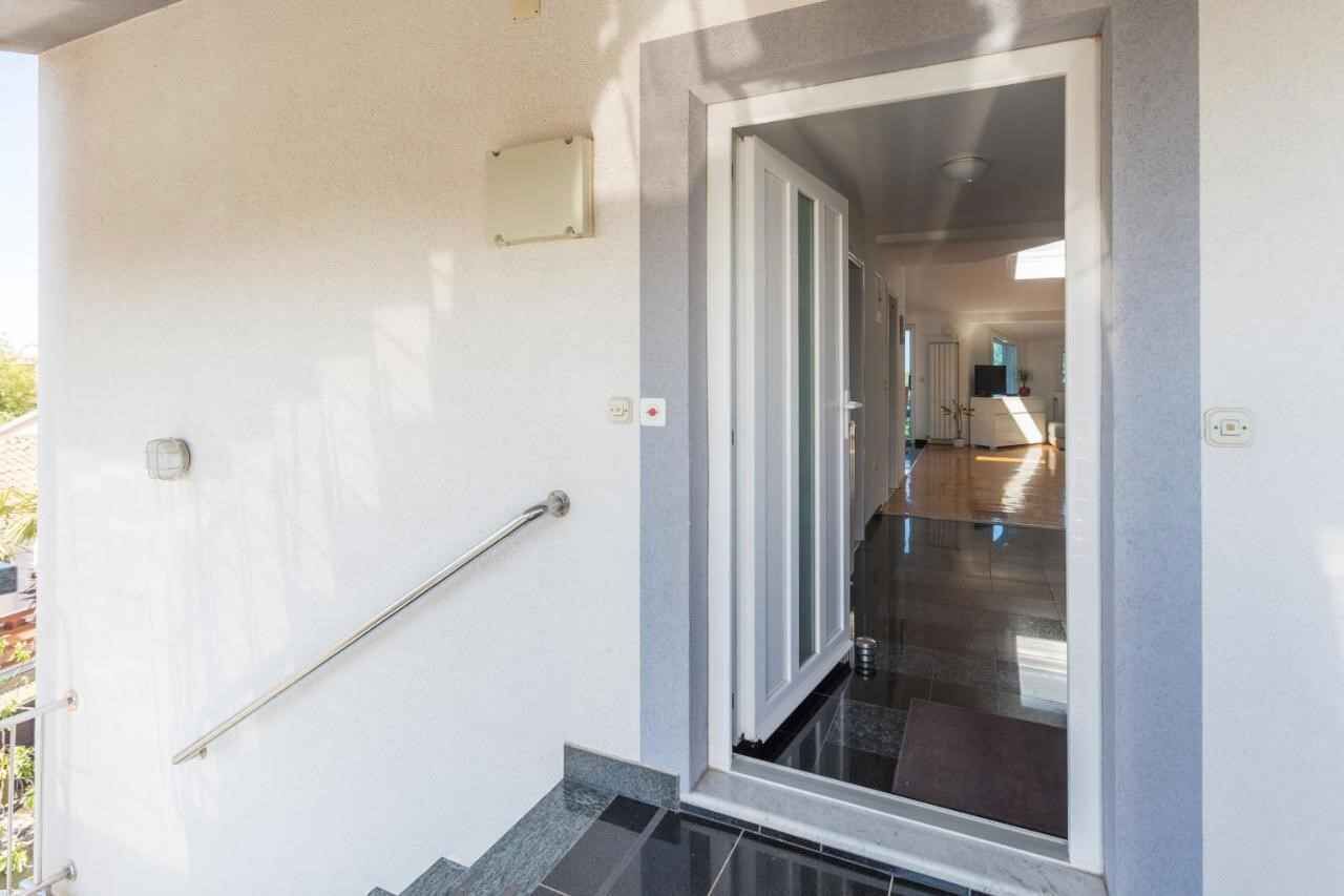 Uma entrada limpa e moderna com porta de vidro que dá para um corredor.