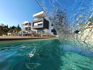 Vista nitida di una piscina con un edificio moderno sullo sfondo.