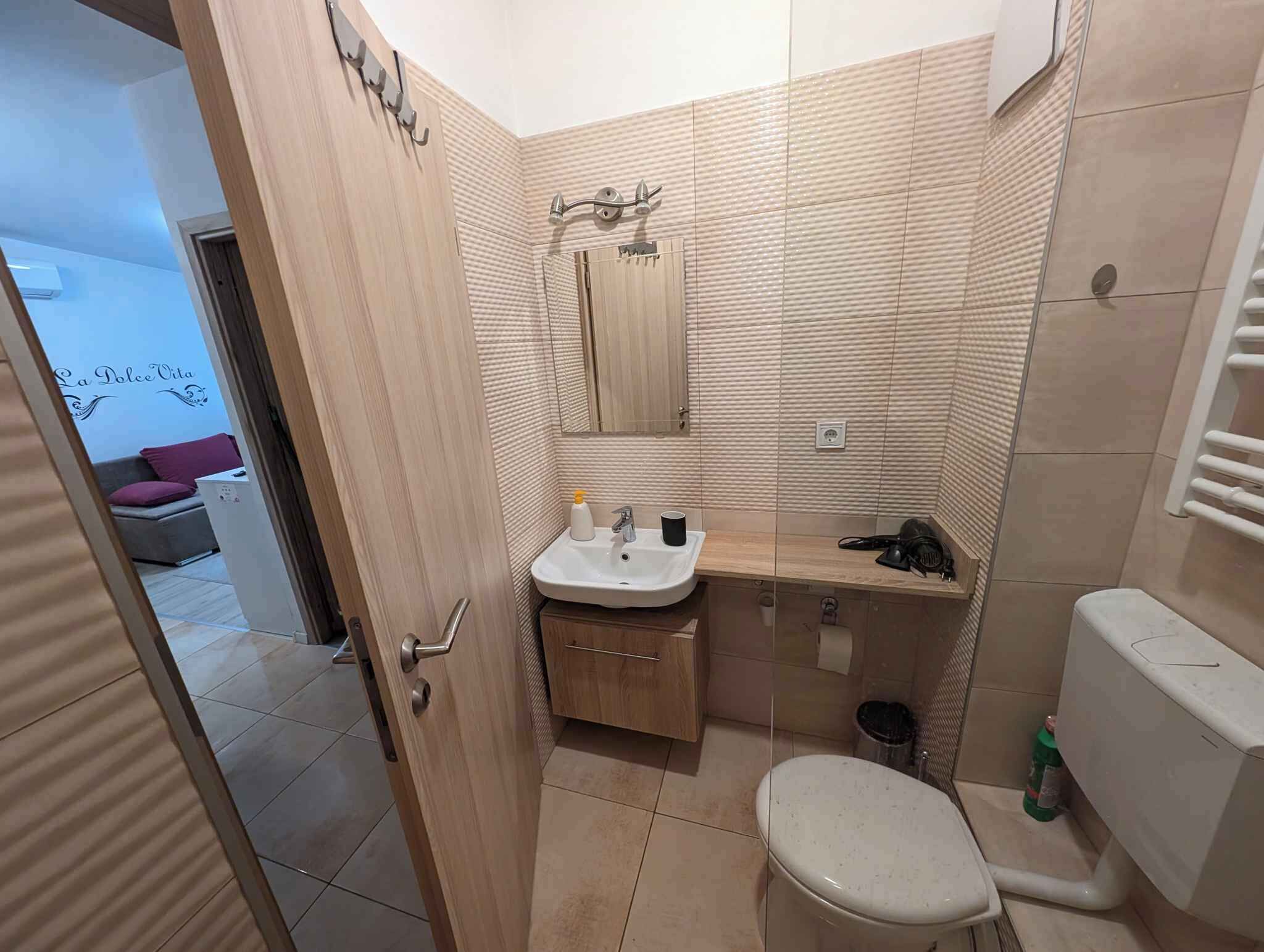 Een kleine badkamer met een wastafel, spiegel en toilet.