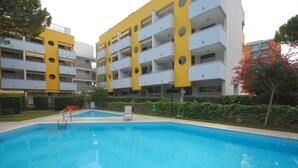 Una piscina circondata da un edificio moderno con balconi.