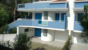Ein modernes, zweistöckiges Gebäude mit blauen und weißen Außenwänden, einem Balkon und einer Satellitenschüssel.