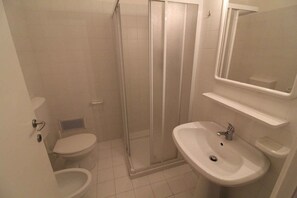 A bathroom with a shower enclosure, toilet, and sink. - Holiday apartment with large corner terrace (Lignano Sabbiadoro)