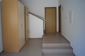 A staircase leading to a door with a wooden frame and a metal handrail. - Studio with air conditioning (Pula)