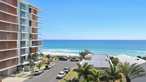 Um hotel de vários andares com varandas com vista para a praia.