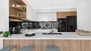 Cozinha moderna com ilha central, banquetas e vista para a paisagem urbana.