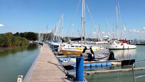 Un port de plaisance où de nombreux voiliers sont amarrés le long d’une jetée en bois.