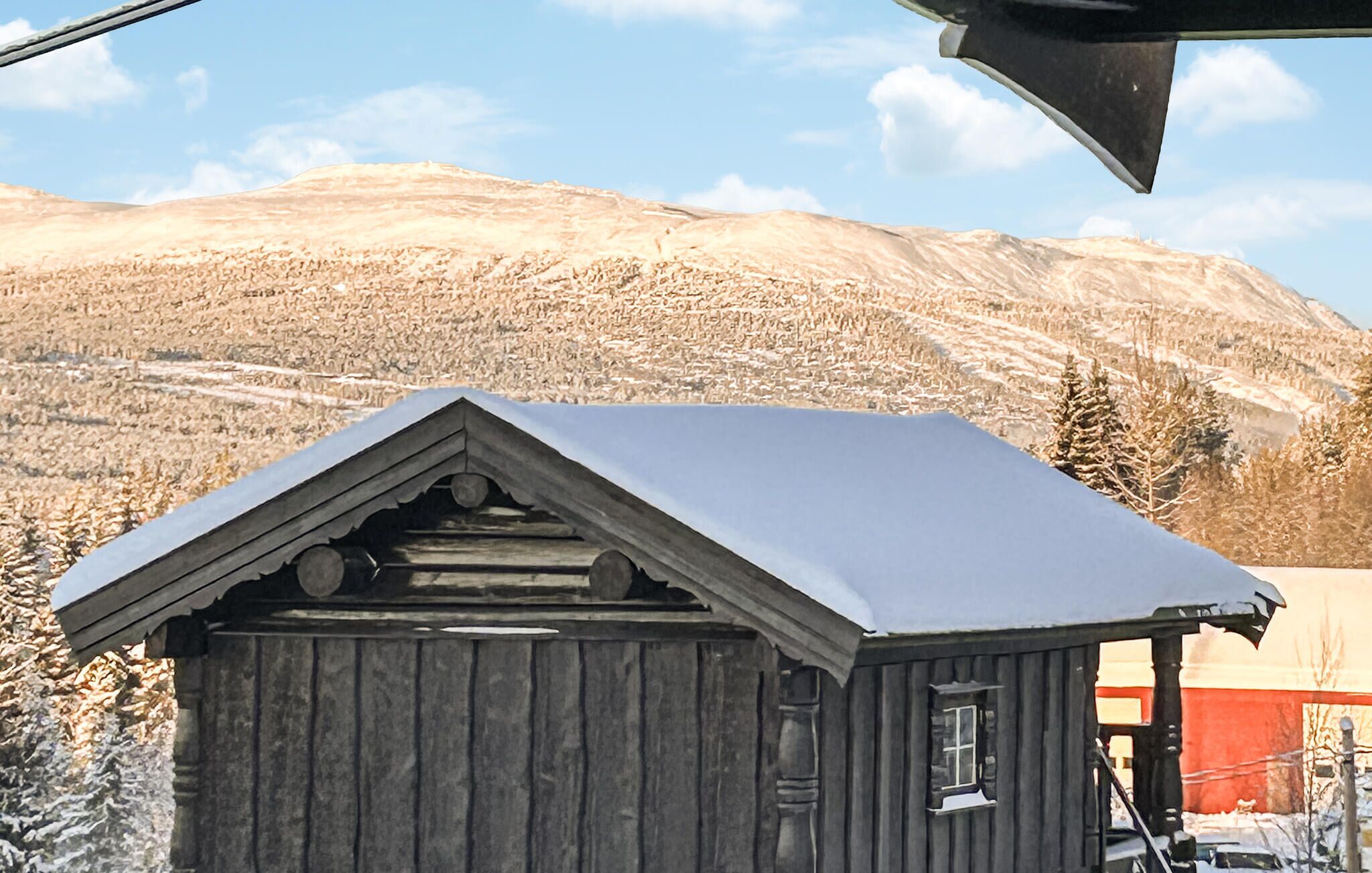 A small wooden cabin with a gabled roof, a window, and a door.