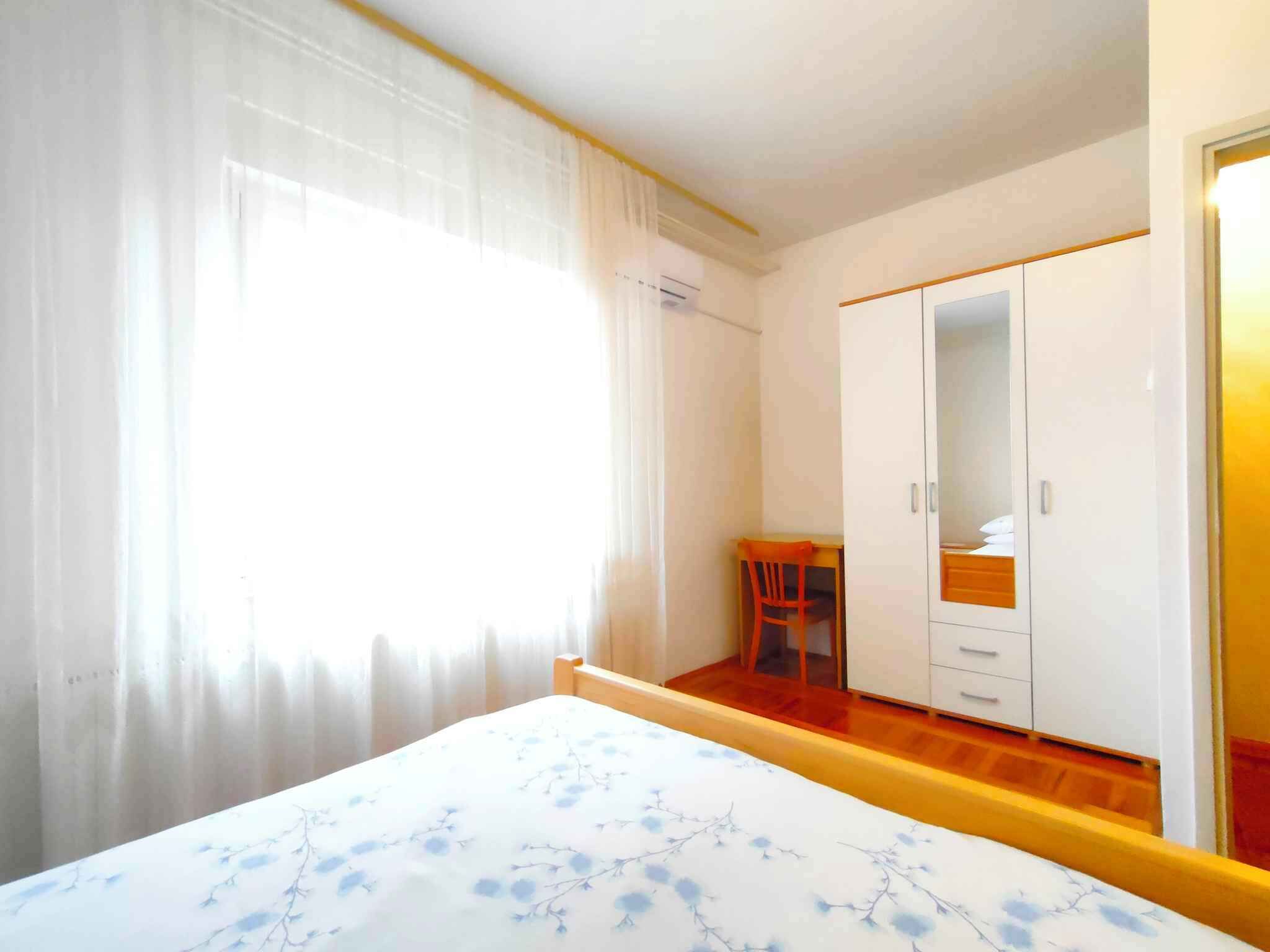 Un dormitorio con cama, escritorio, silla y armario.
