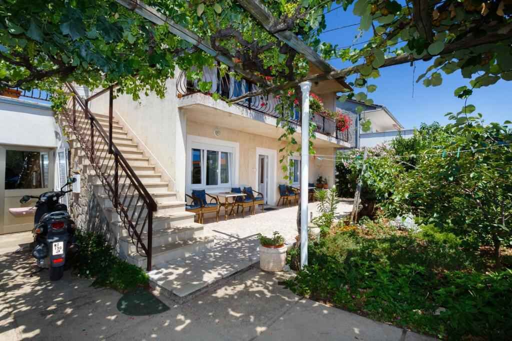 A two-story building with a balcony, outdoor seating area, and a staircase.