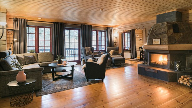 A cozy living room with a fireplace, wooden floors, and large windows. - 2 bedroom gorgeous apartment in Bjorli (Bjorli)