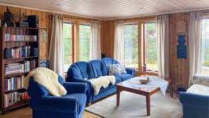 Un salon chaleureux avec un canapé bleu, une table basse en bois et une bibliothèque remplie de livres.