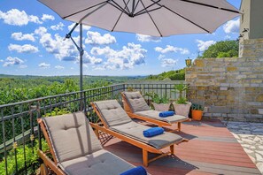 A terrace with three sun loungers, a large umbrella, and a stone wall. - Villa WITH POOL AND GARDEN (Momjan)