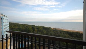 Een balkon met uitzicht op een strand en zee.