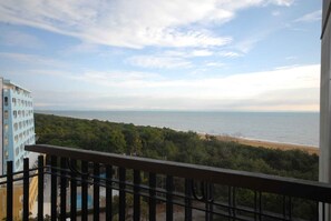 Ein Balkon mit Blick auf Strand und Meer.