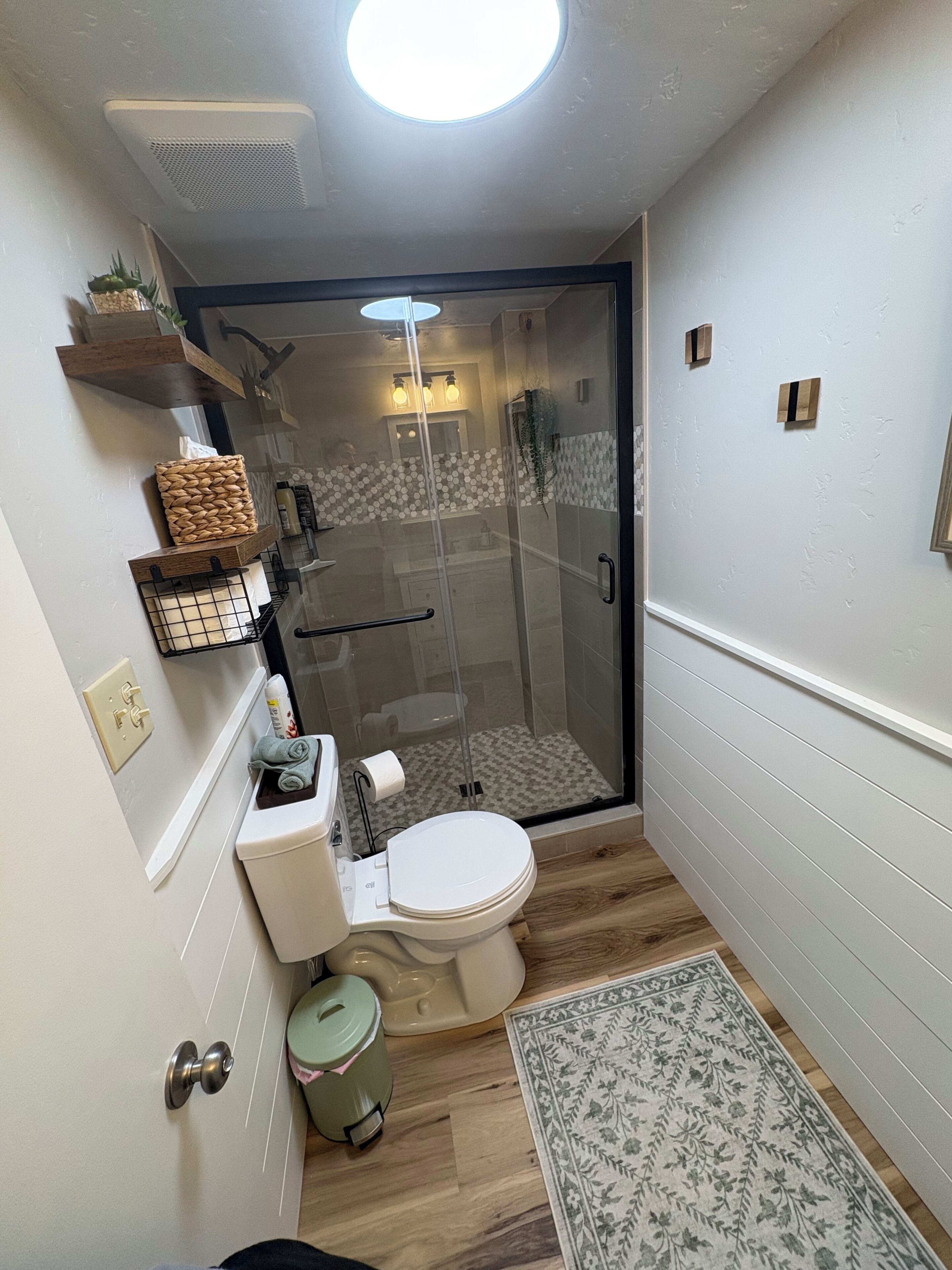 Un baño pequeño con inodoro, ducha y una ventana.