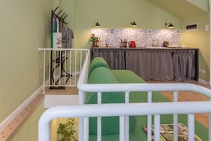 A cozy kitchen with a tiled backsplash, a small bar area, and a green cushioned seating area. - Little Bucharest Mansion  (Bucharest)
