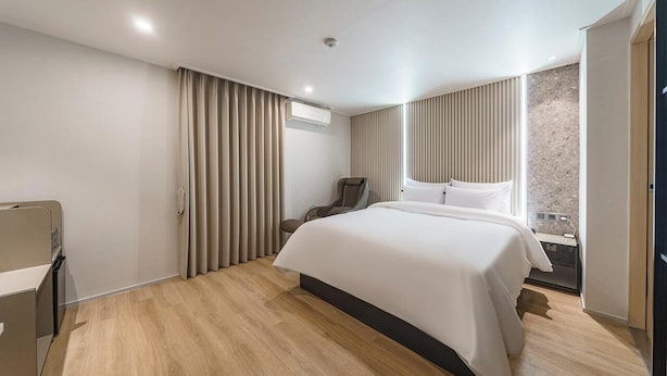 Et moderne hotelværelse med en stor seng, et skrivebord og en stol.