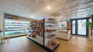 En godt oplyst butik med hylder fyldt med snacks og drikkevarer.