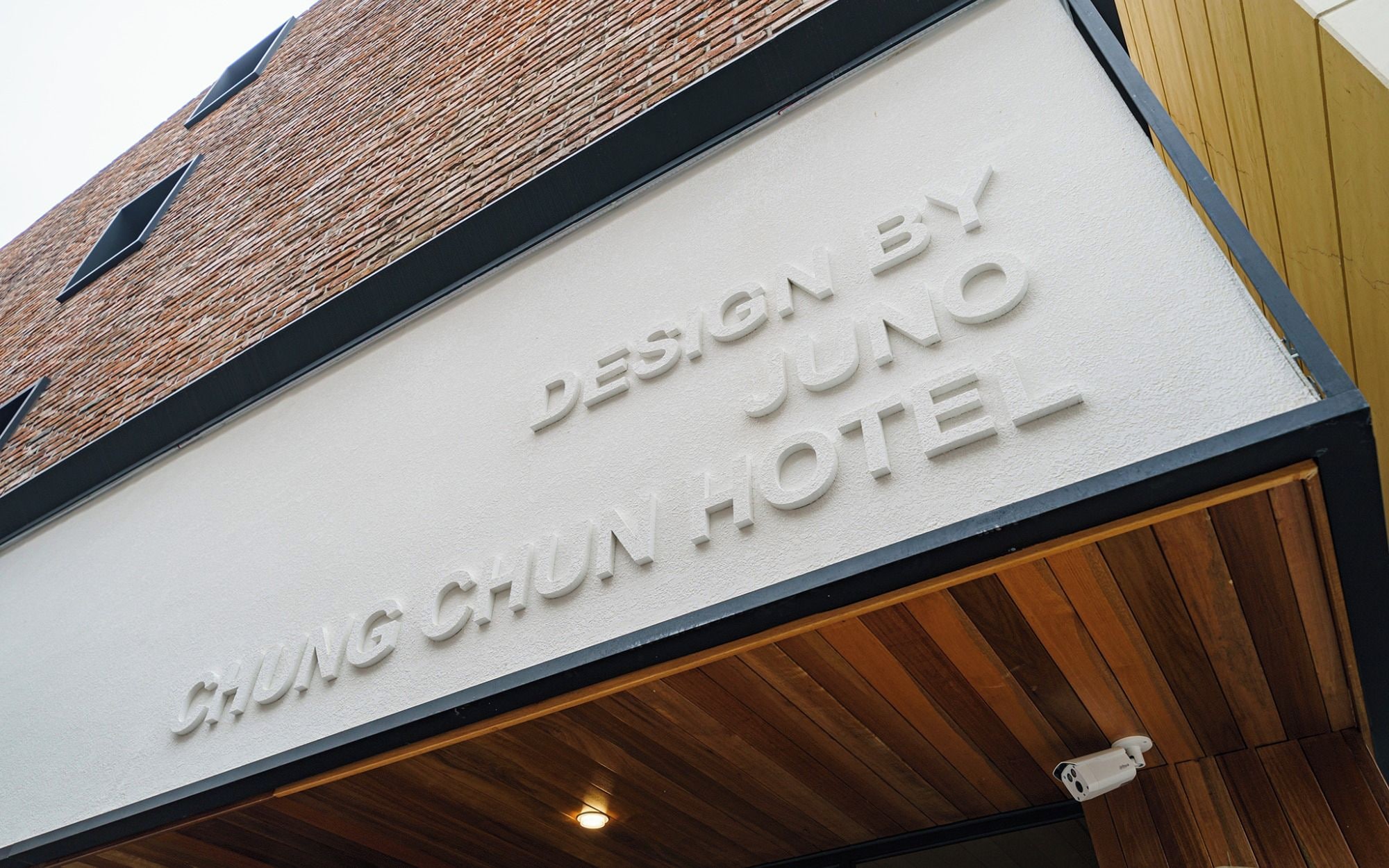 Un letrero de hotel con el texto 'DESIGN BY JUNO CHING CHUN HOTEL'.