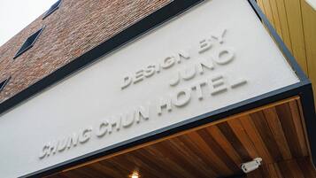 Un letrero de hotel con el texto 'DESIGN BY JUNO CHING CHUN HOTEL'.