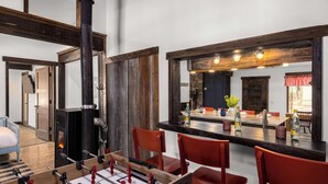 A cozy room with a foosball table, a fireplace, and a dining area with red chairs and a bar counter. - River's Ranch - Riverfront with Hot Tub & Theater (Kalispell)