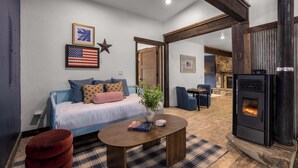 A cozy living room with a sofa, a coffee table, and a fireplace. - River's Ranch - Riverfront with Hot Tub & Theater (Kalispell)