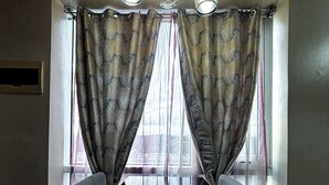 A room with a window, curtains, and a light fixture.