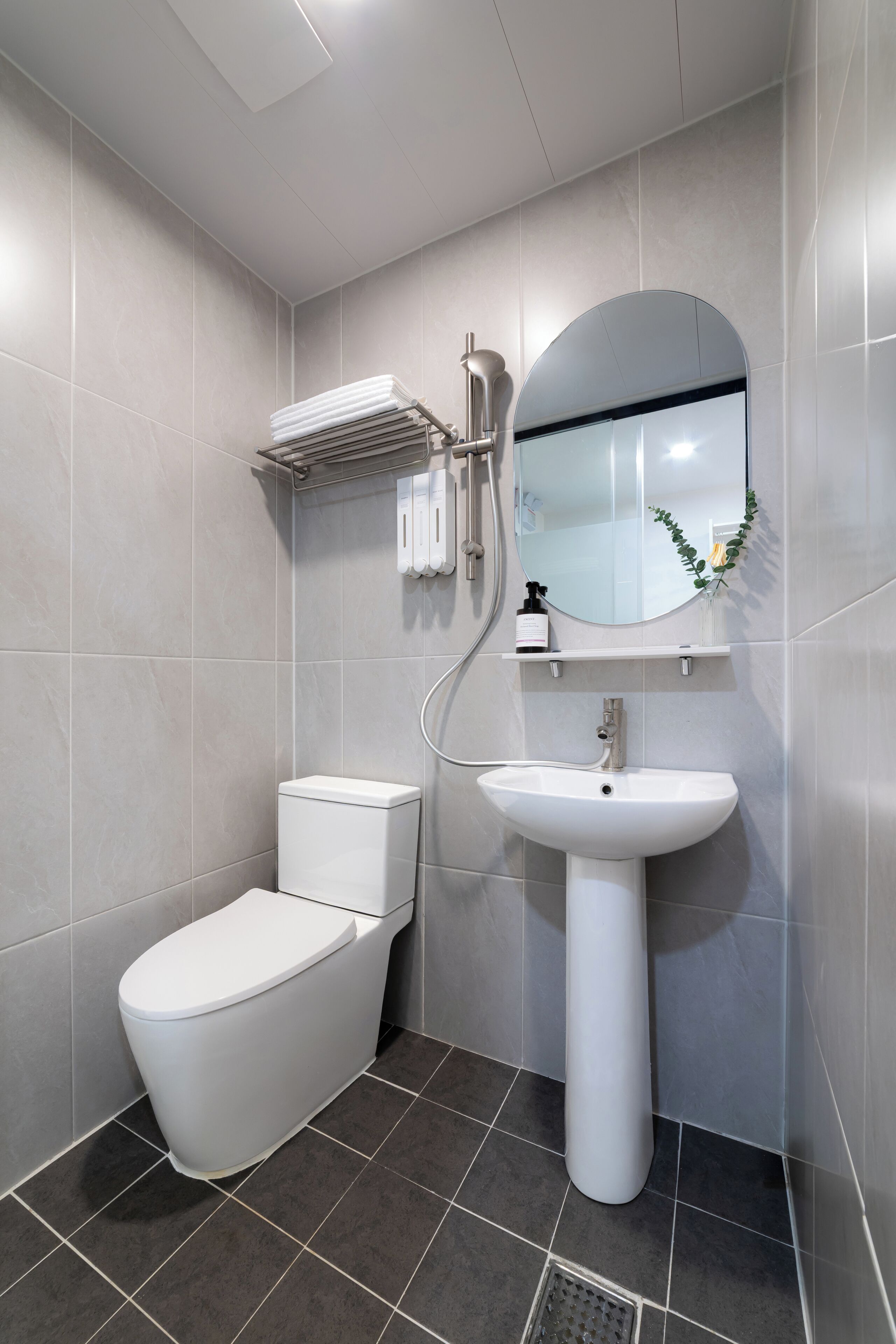 A modern bathroom with a toilet, sink, and shower.