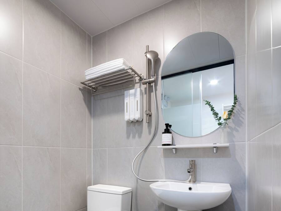 A modern bathroom with a toilet, sink, and shower.