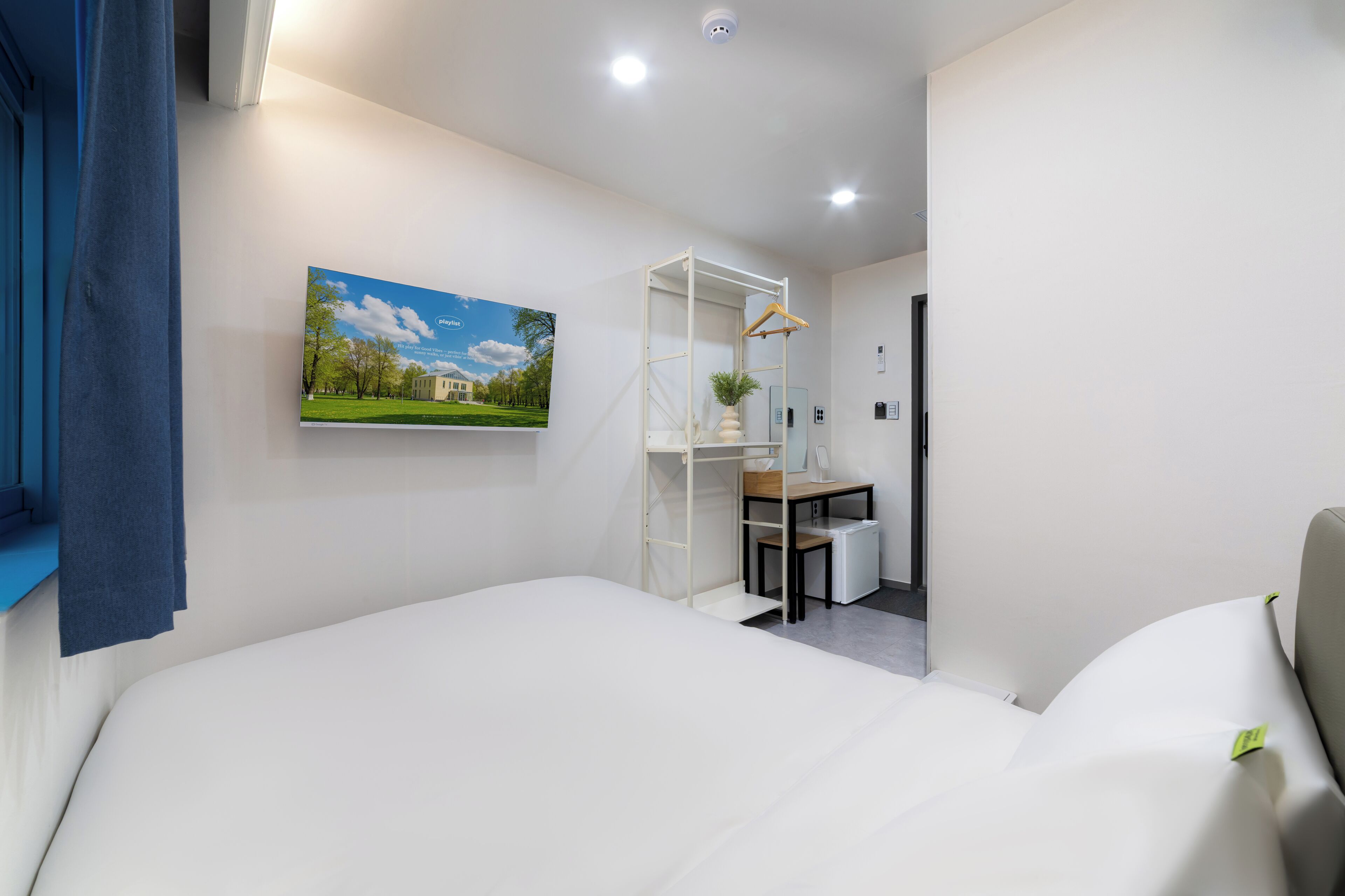 A bedroom with a bed, a desk, and a chair.