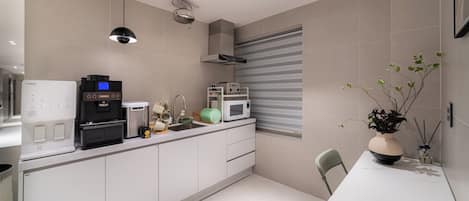 A modern kitchen with a coffee machine, microwave, and toaster.