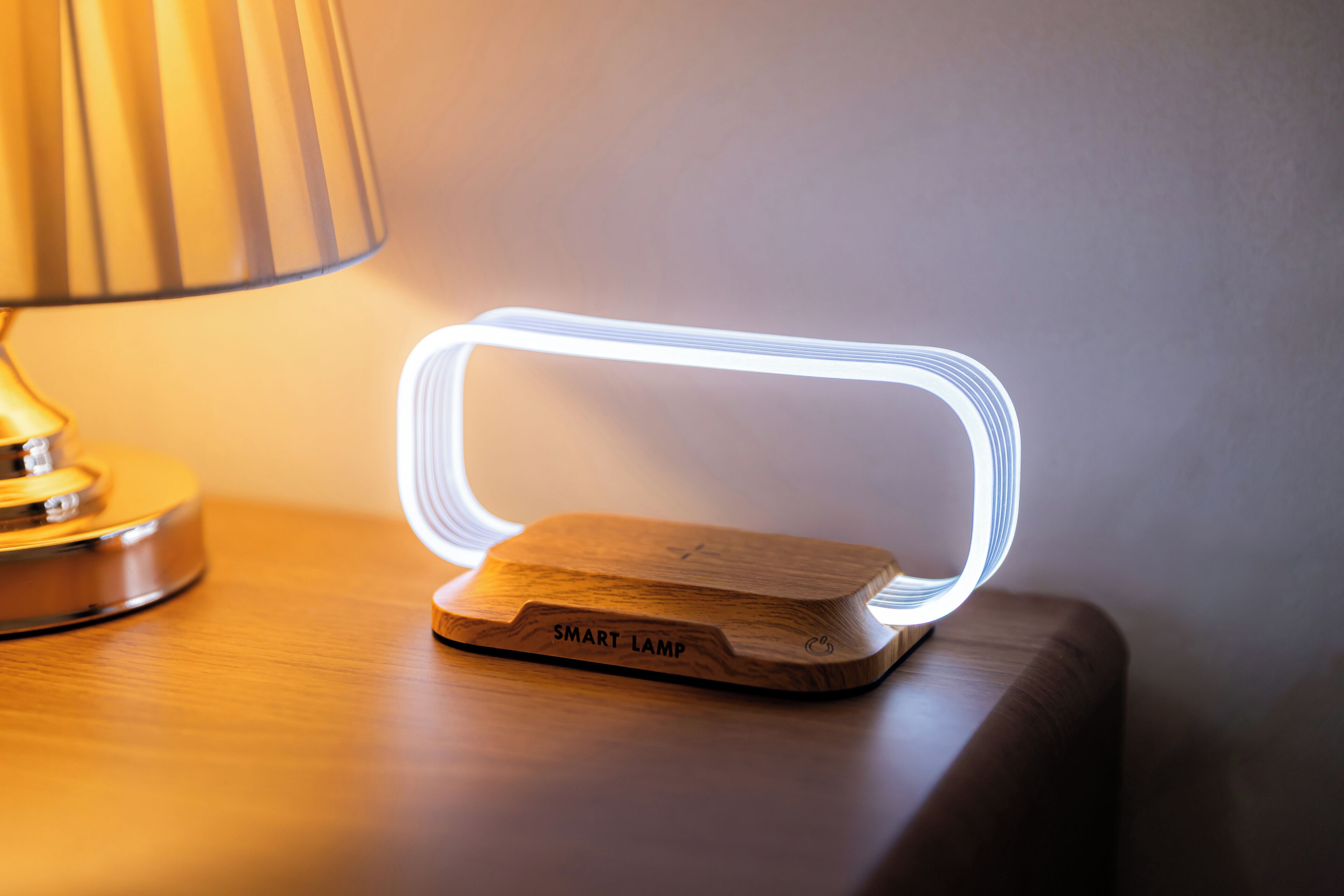 A smart lamp with a wooden base and a clear, illuminated case on a wooden surface.
