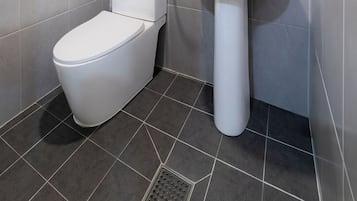 A modern bathroom with a toilet, sink, and shower.