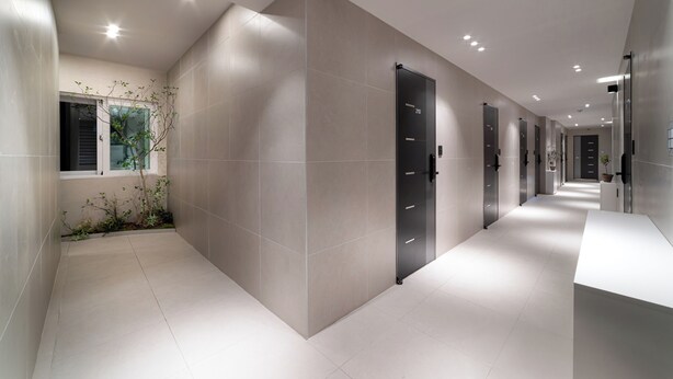 A modern hallway with a tiled floor, a door with a number, and a window with a plant. - Dongdaemun Stay Garden (Seoul)